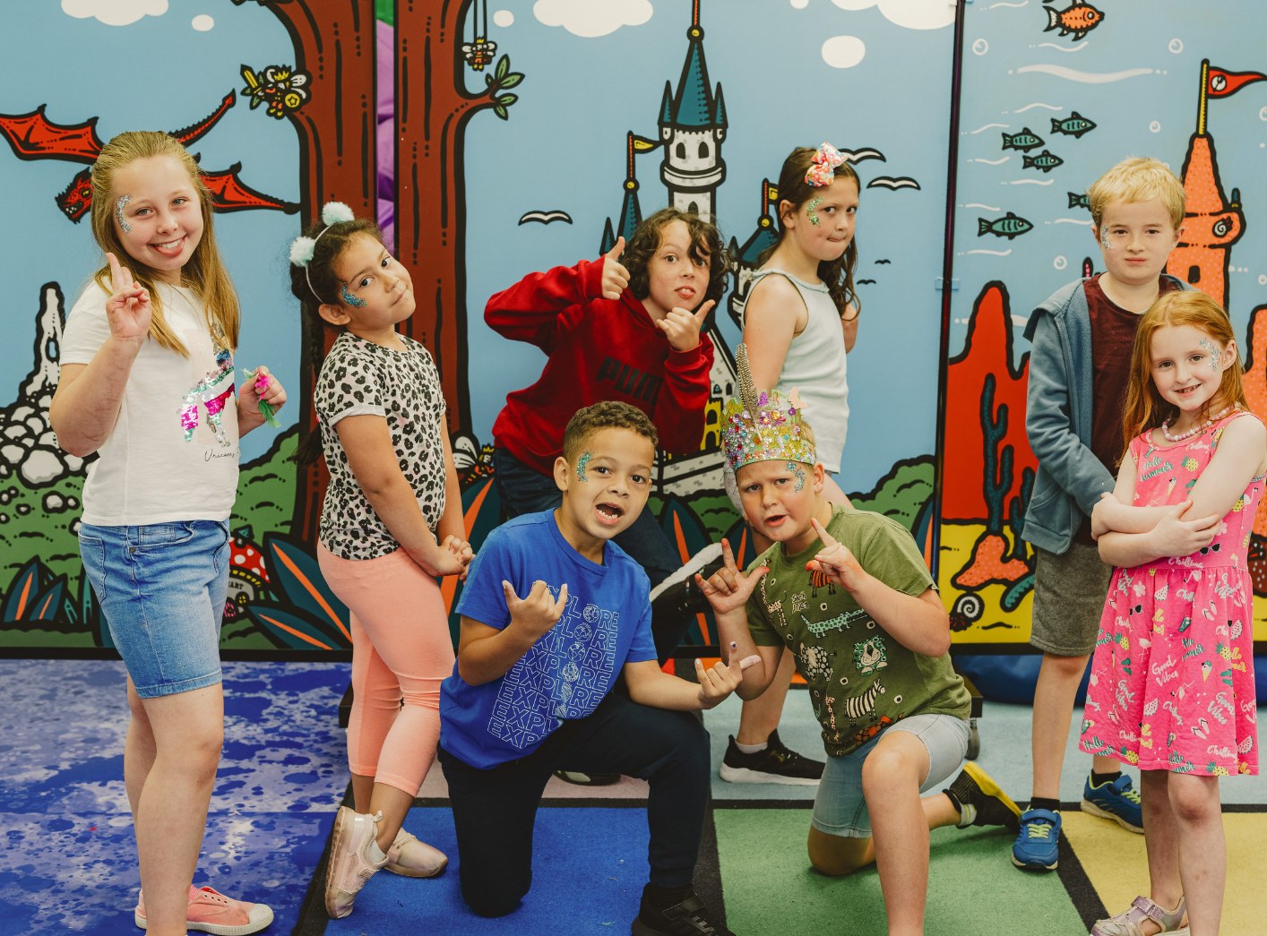 Group of young people posing in front of the Hub mural